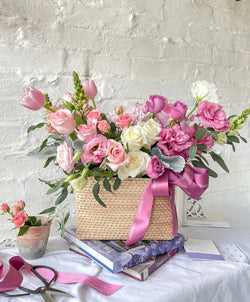 Lucia, cesta con exquisita variedad de flores rosadas.