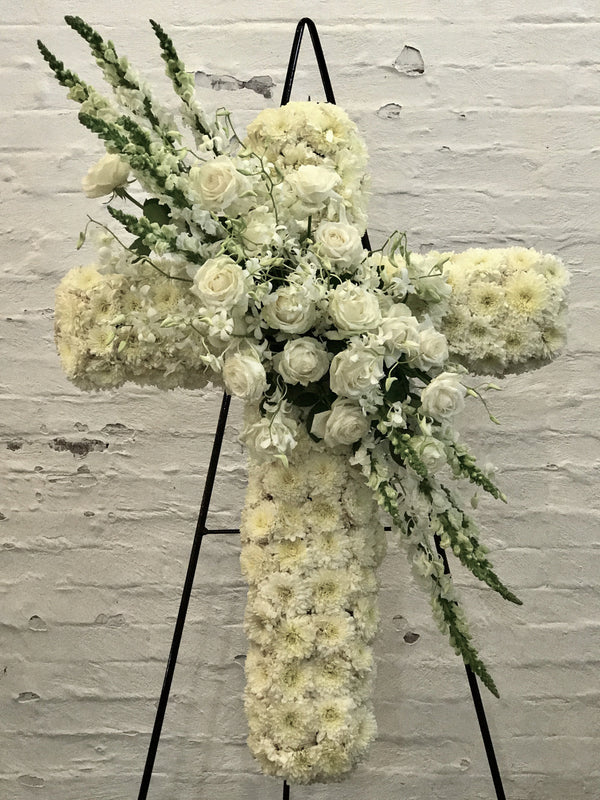 Pureza, cruz para condolencia de rosas blancas  y variedad de flores
